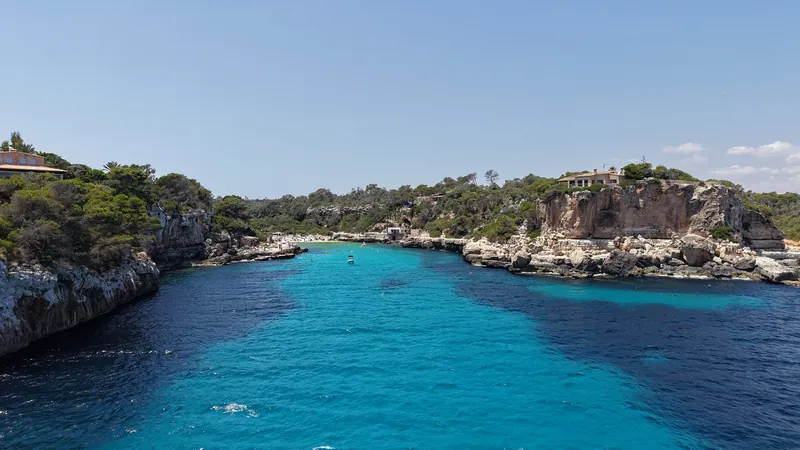 Cala de agua turquesa entre acantilados de Mallorca, vista desde el dron