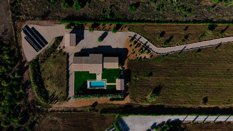Casa de campo moderna con piscina y jardín entre olivos, vista aérea