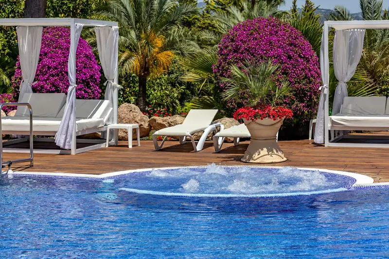 Jacuzzi con camas balinesas y buganvillas en flor