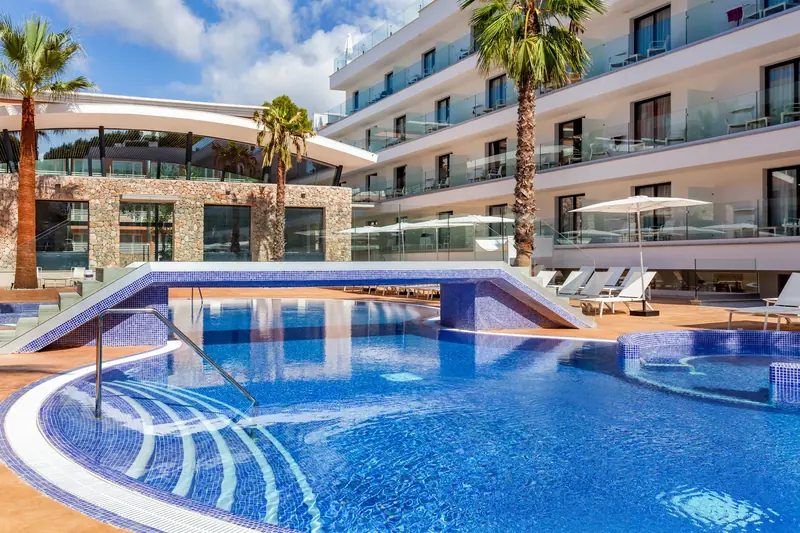 Piscina con puente frente al edificio de habitaciones con balcones