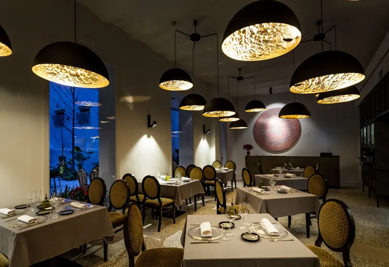 Restaurante de hotel con lámparas de campana doradas
