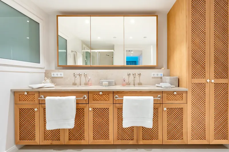 Baño con doble lavabo y armario de celosía de madera