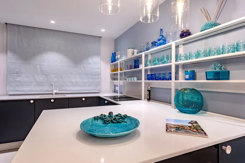 Cocina blanca con piezas de vidrio azul