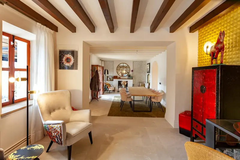 Estancia con vigas de madera, butaca y mueble lacado en rojo