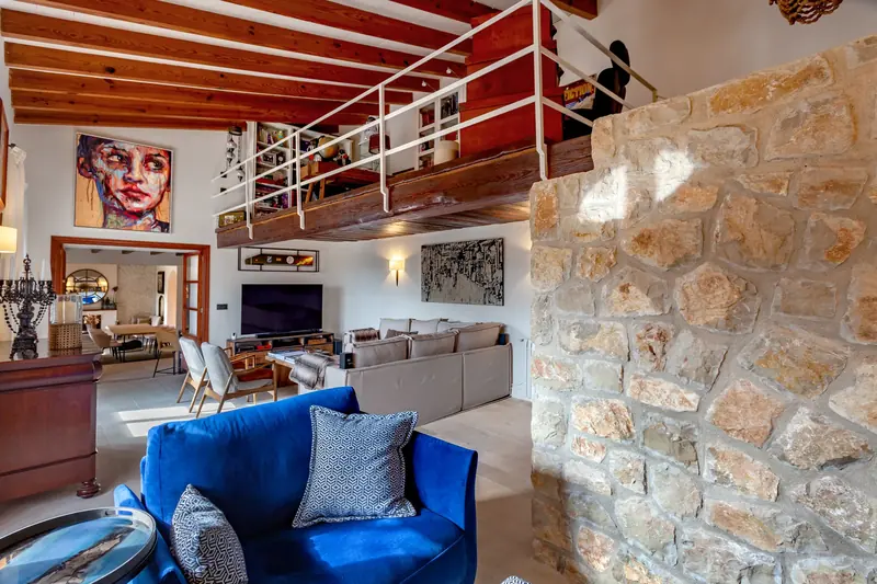 Salón con sillón de terciopelo azul y altillo