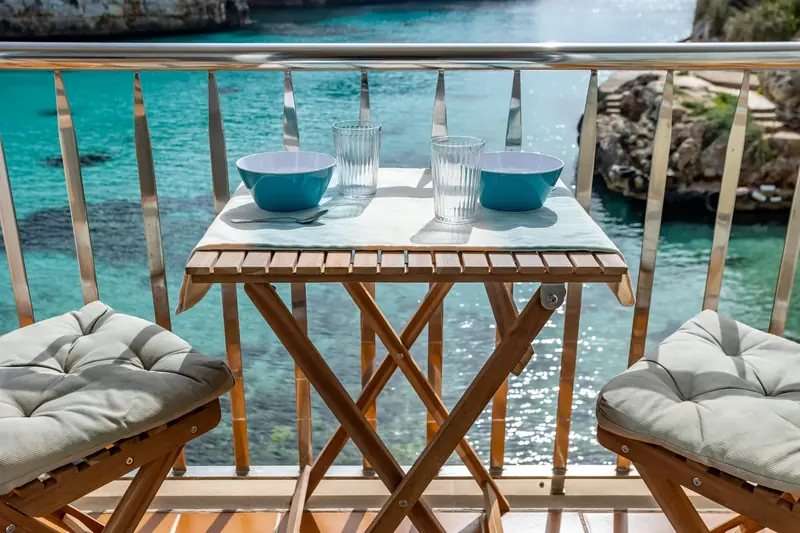 Balcón con mesa para dos y vistas a una cala