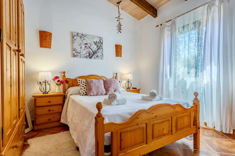 Dormitorio con cama de madera torneada