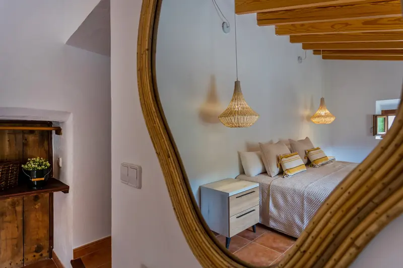 Dormitorio reflejado en un espejo de marco de madera