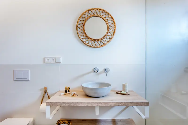 Lavabo de cerámica con espejo de mimbre