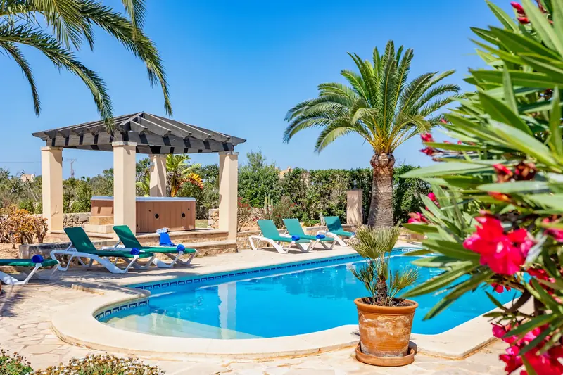 Piscina con pérgola y adelfas en flor